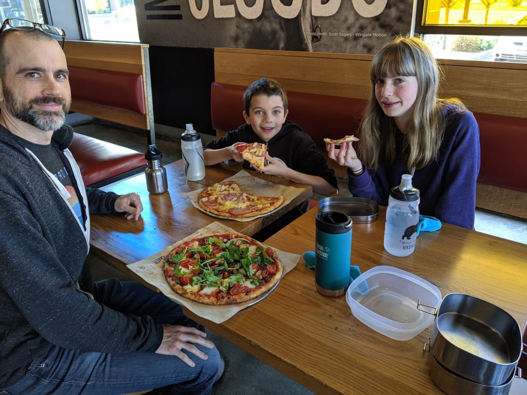 Eating pizza with empty storage containers for leftovers