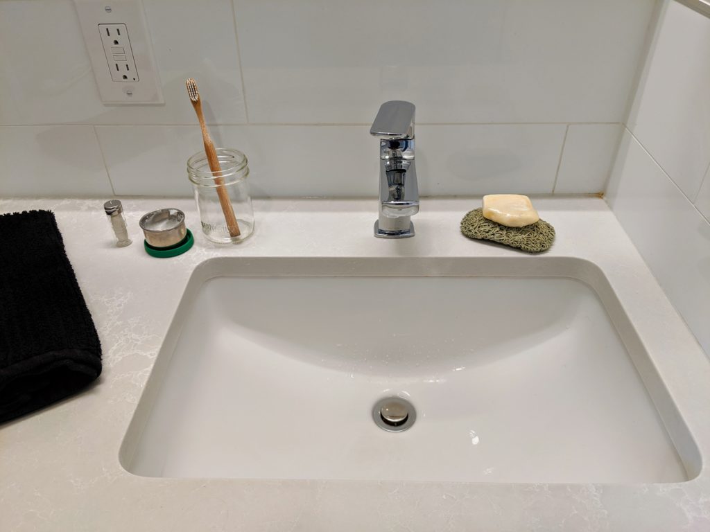 zero waste bathroom including silk dental floss, home made toothpaste, bamboo toothbrush, local made bar soap